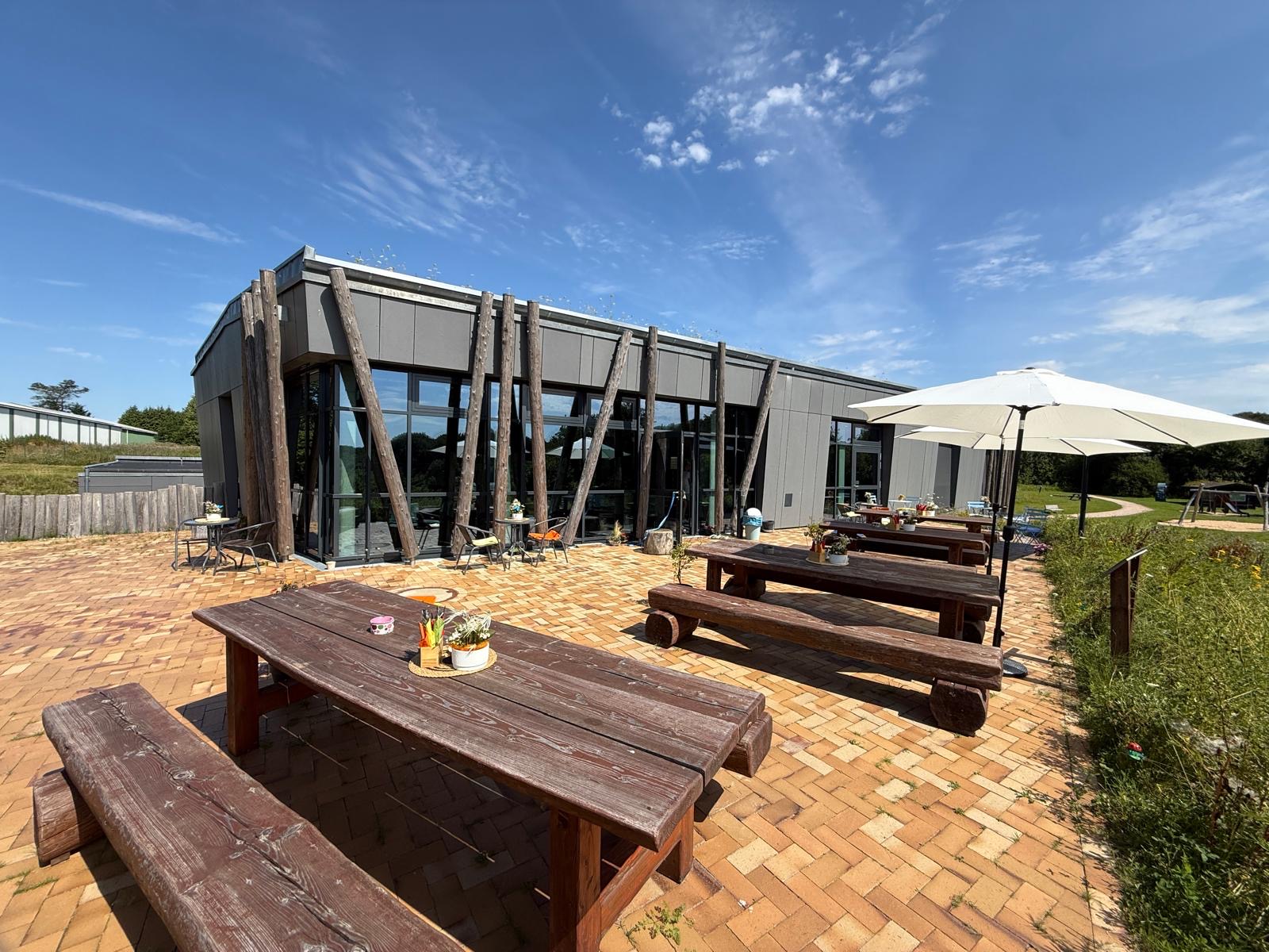 Außenbereich des Steinzeit-Cafes mit Terrasse und Sitzbänken