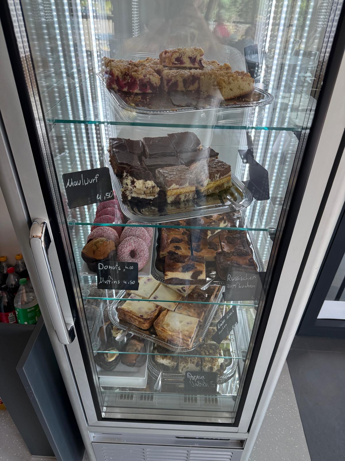 Kuchenvitrine mit hausgebackenen Kuchen und Gebäck im Steinzeit-Cafe