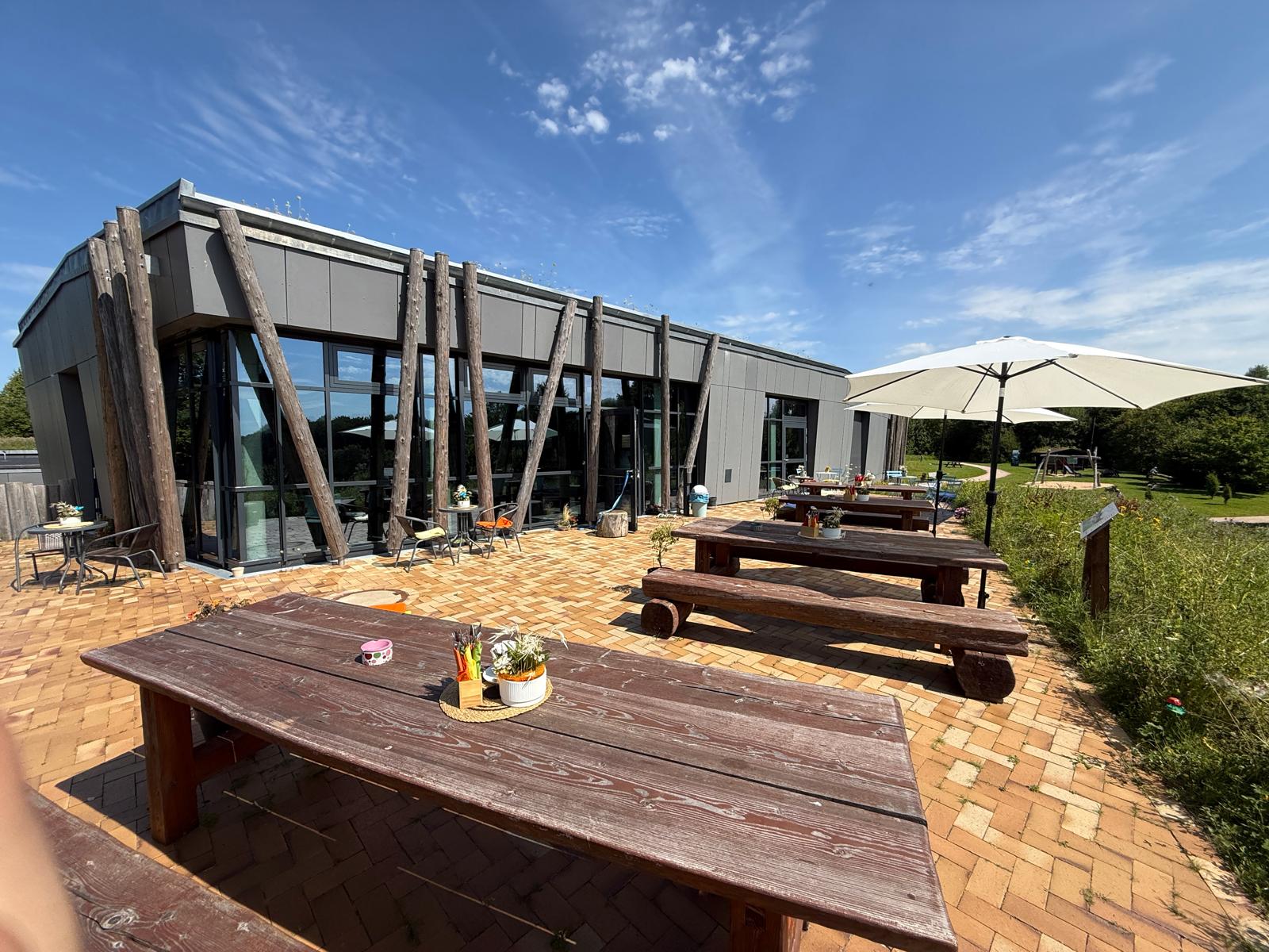 Außenbereich des Steinzeit-Cafes im Steinzeitpark Dithmarschen mit Terrasse und Sitzplätzen